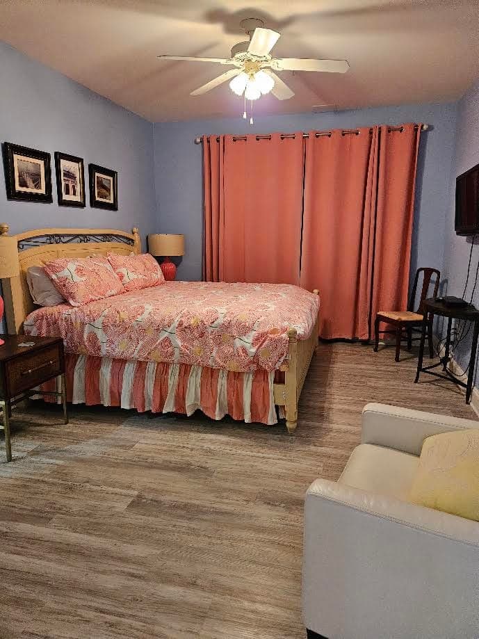 Bedroom with a queen bed, coral bedding, and curtains